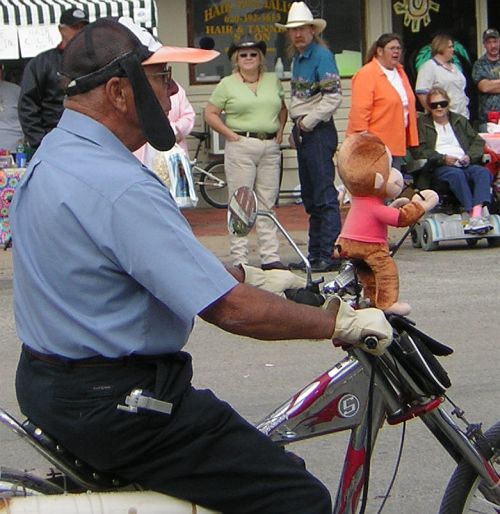 man with funny hat and monkey on handlebars